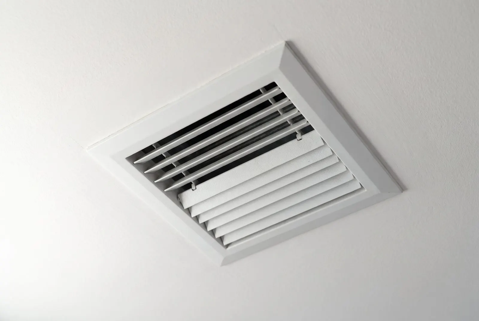 Ceiling supply register with its louvers half closed