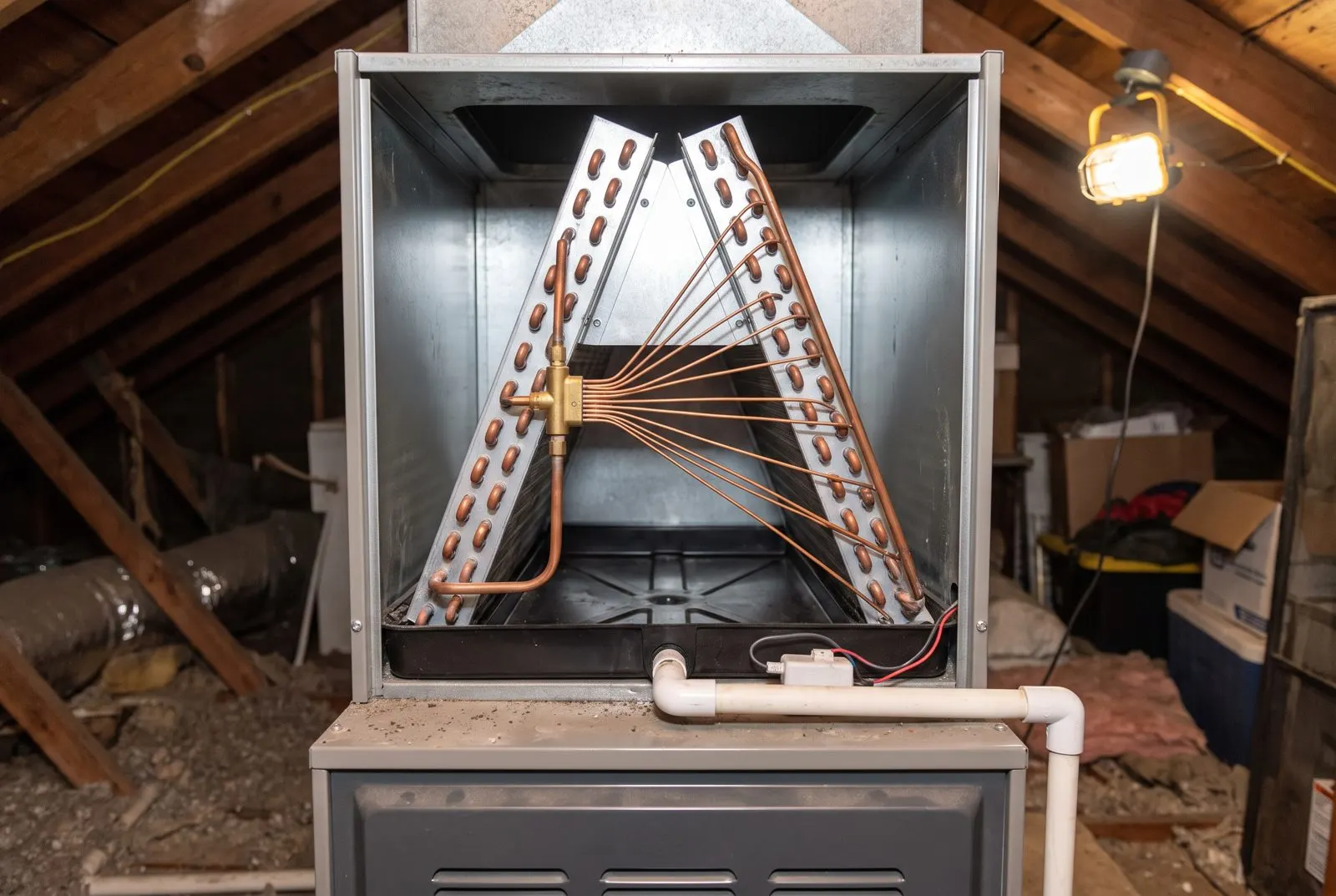 Evaporator coil and drain pan inside an attic coil cabinet