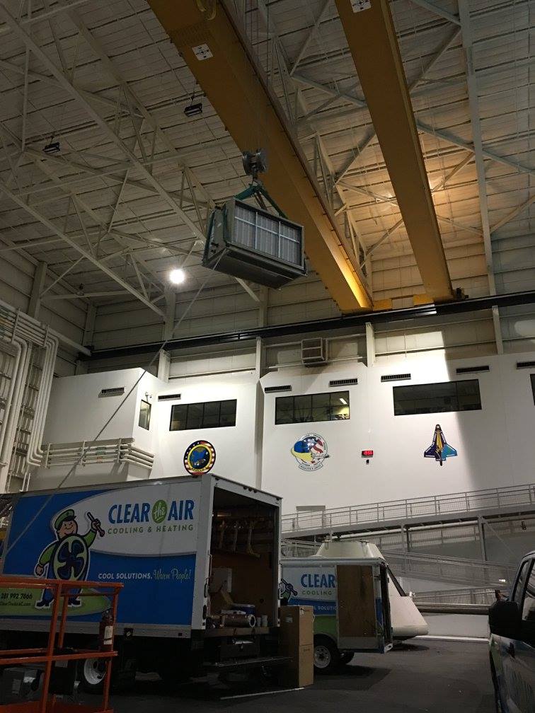 New air handler suspended from the overhead bridge crane during installation